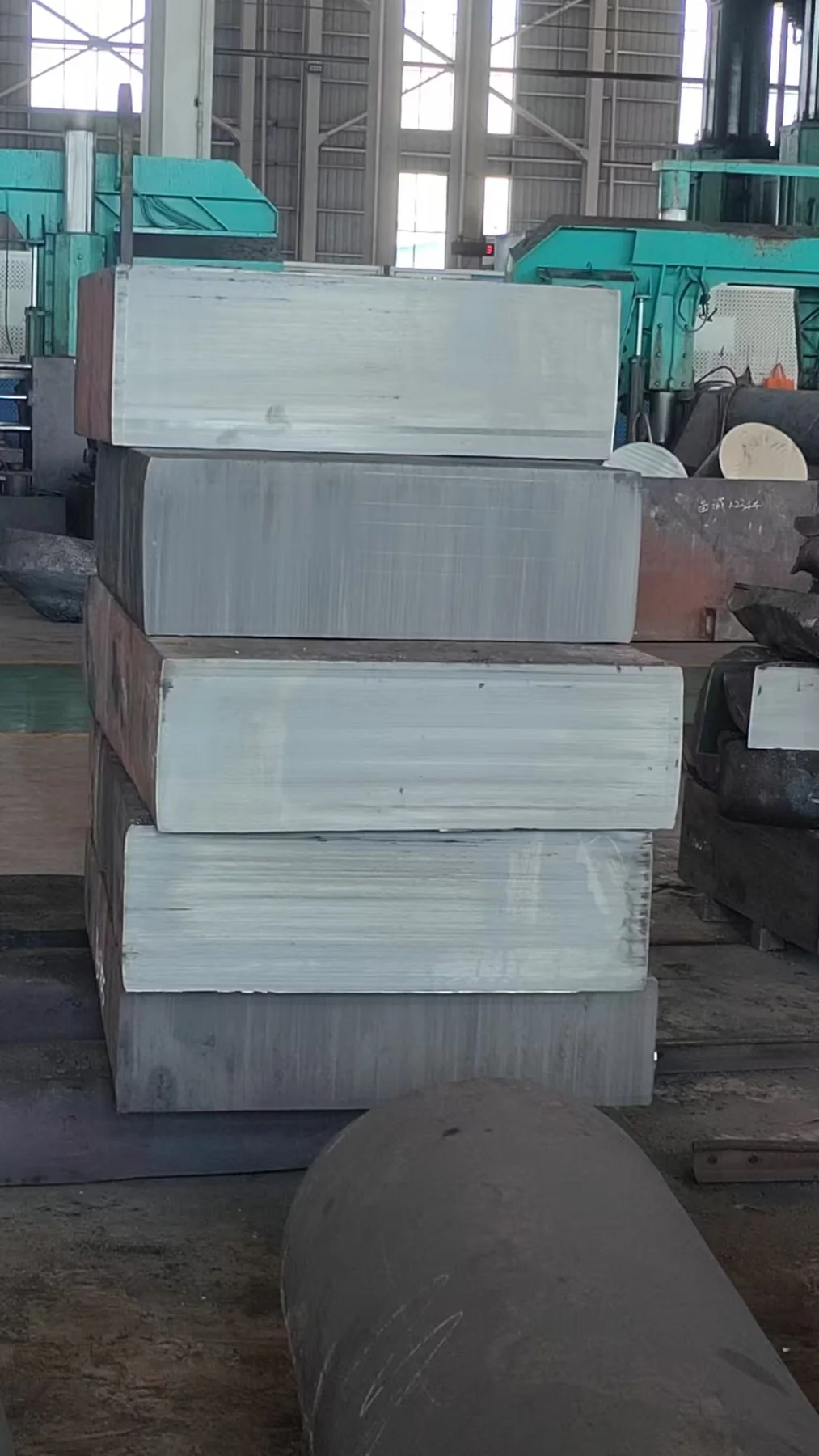 Large machined steel blocks stacked in the workshop